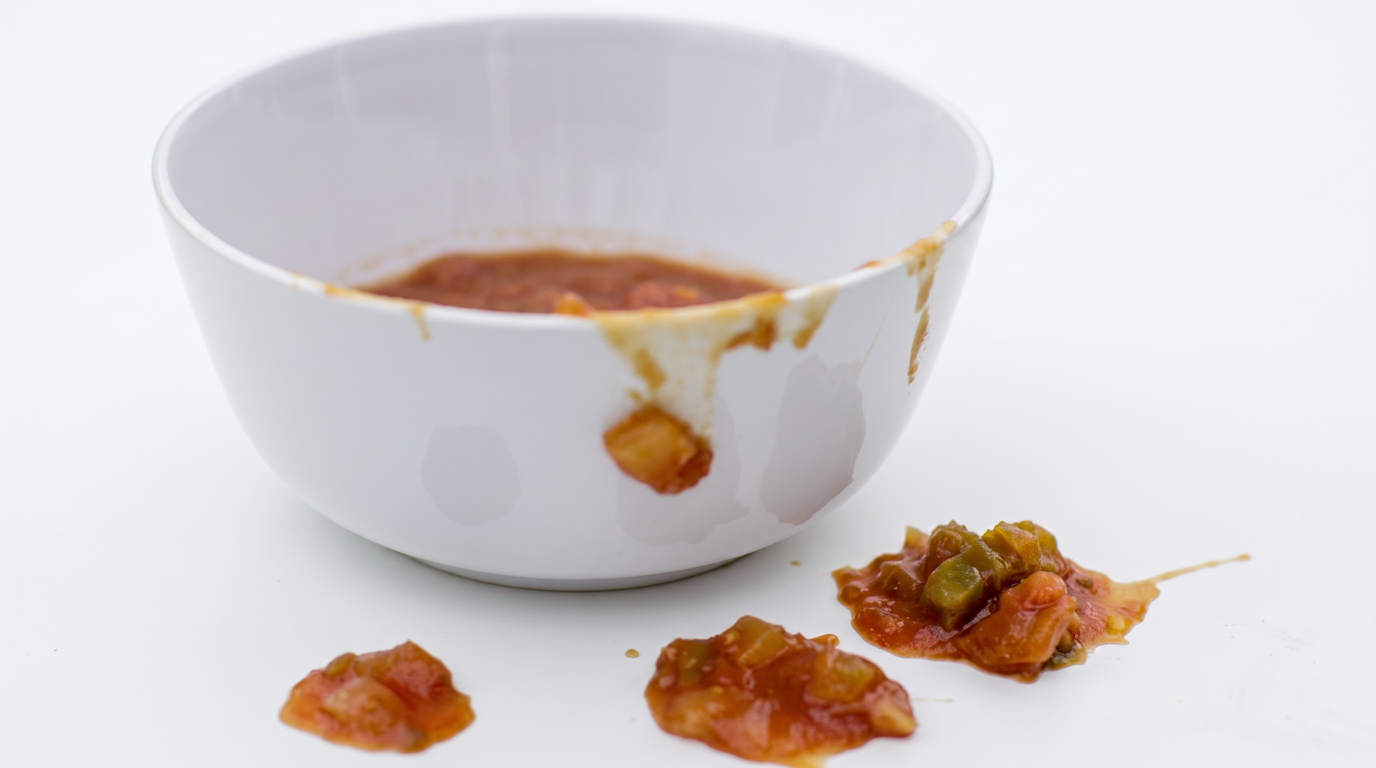 A traditional round bowl with salsa smeared down the side